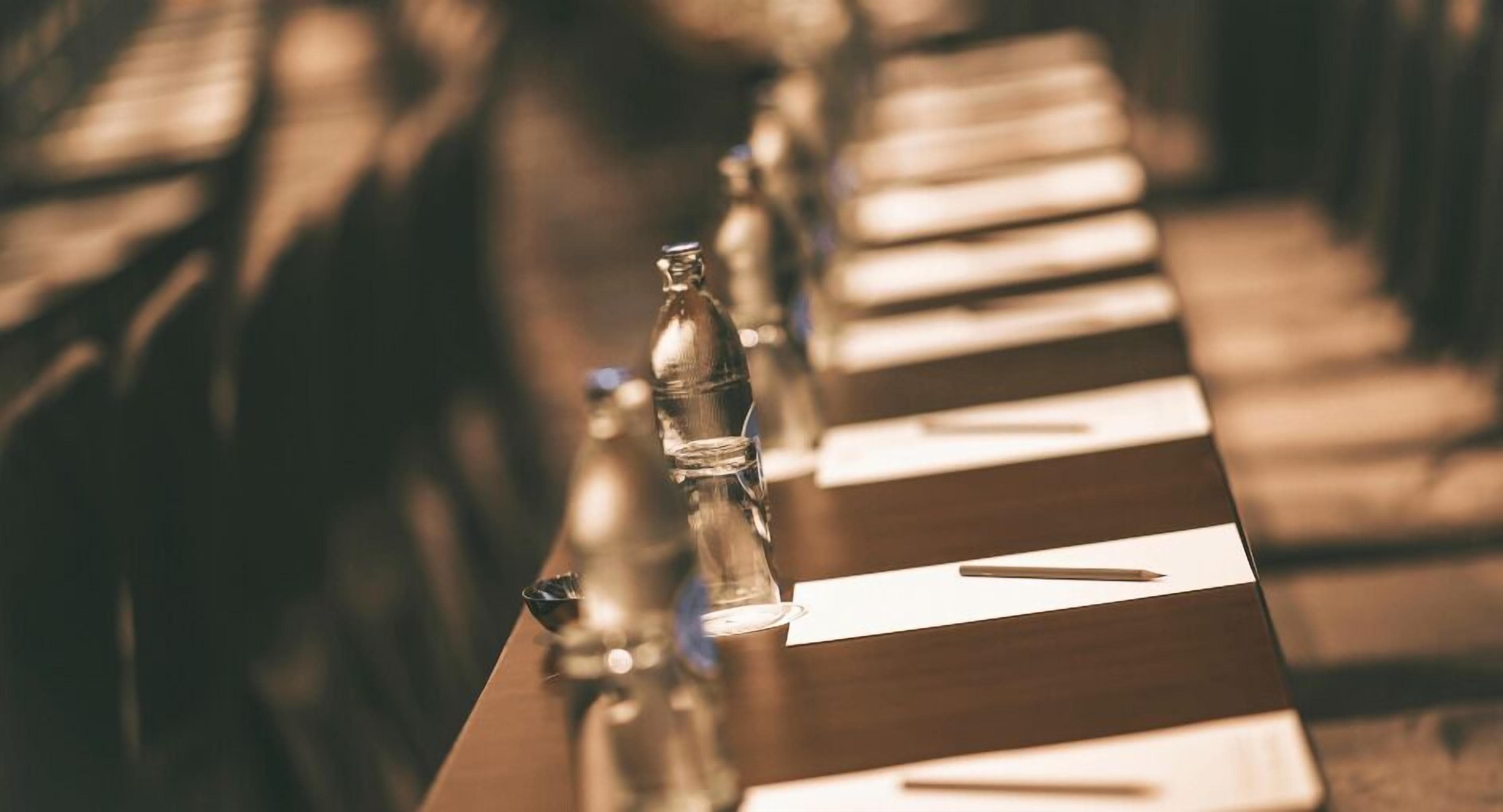 A row of piano keys with a bottle of water and a pen on the table.