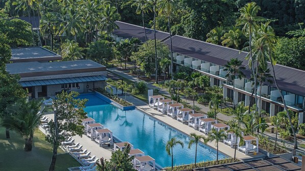 Una piscina al aire libre, camas de piscina gratis, sombrillas