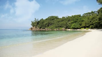 On the beach, white sand, sun loungers, beach towels