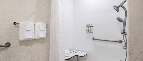 Une salle de bain moderne avec une douche, un petit lavabo et un porte-serviettes.