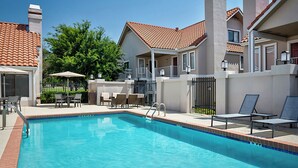 Una piscina amb gandules i una zona de pati coberta.