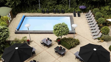 Una piscina al aire libre de temporada, sombrillas