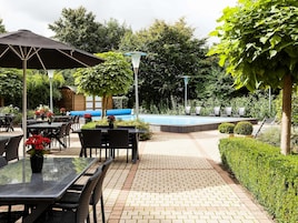 Una piscina al aire libre de temporada, sombrillas