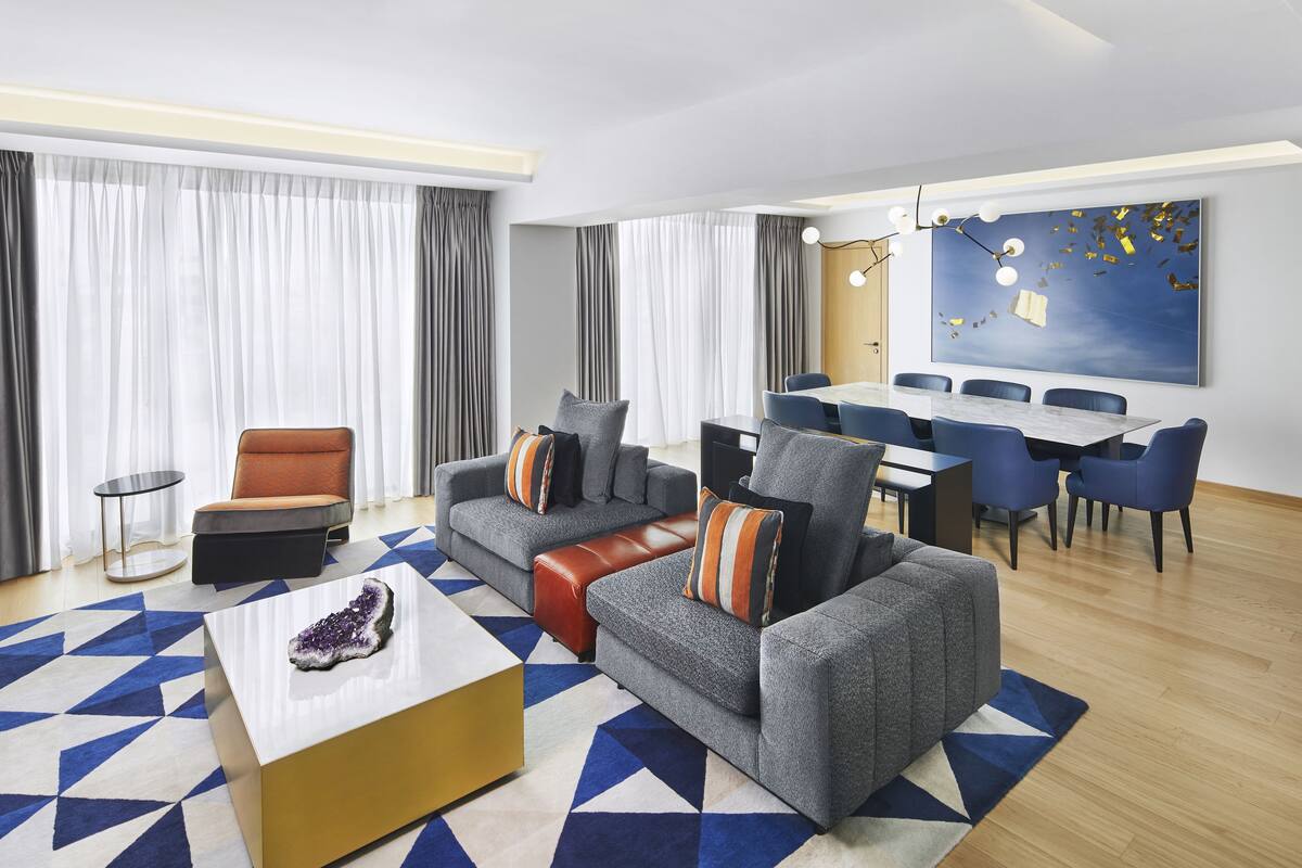 Un salon moderne comprenant un canapé, une table basse et un coin repas avec une table et des chaises.
