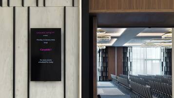 A hotel interior with a black sign indicating an event at Grand Hyatt Athens on Monday, 16 January 2023 at 10:52, and a caption "Caryatids I".