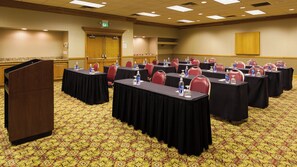 A conference room with multiple tables, chairs, and a podium. - Holiday Inn Cincinnati Airport by IHG (Hebron)