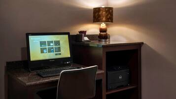 A hotel reception desk with a Lenovo computer, a lamp, and a Dell printer.