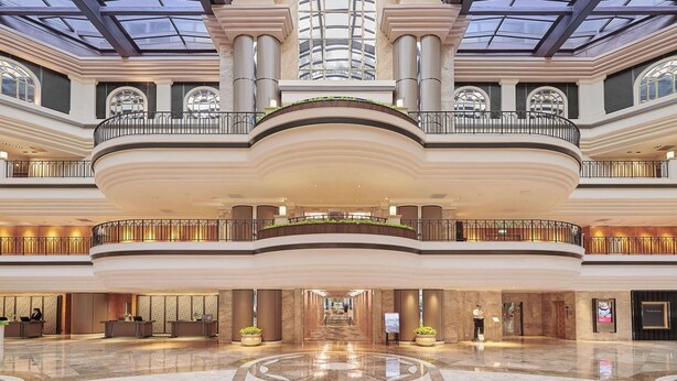 A spacious atrium with a high ceiling, large windows, and a central staircase. - Grand Hyatt Taipei (Taipei)