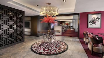 A modern hotel lobby with a round table, a decorative vase, and a patterned carpet.