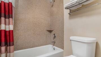 Une salle de bain avec une baignoire, des toilettes et une douche.