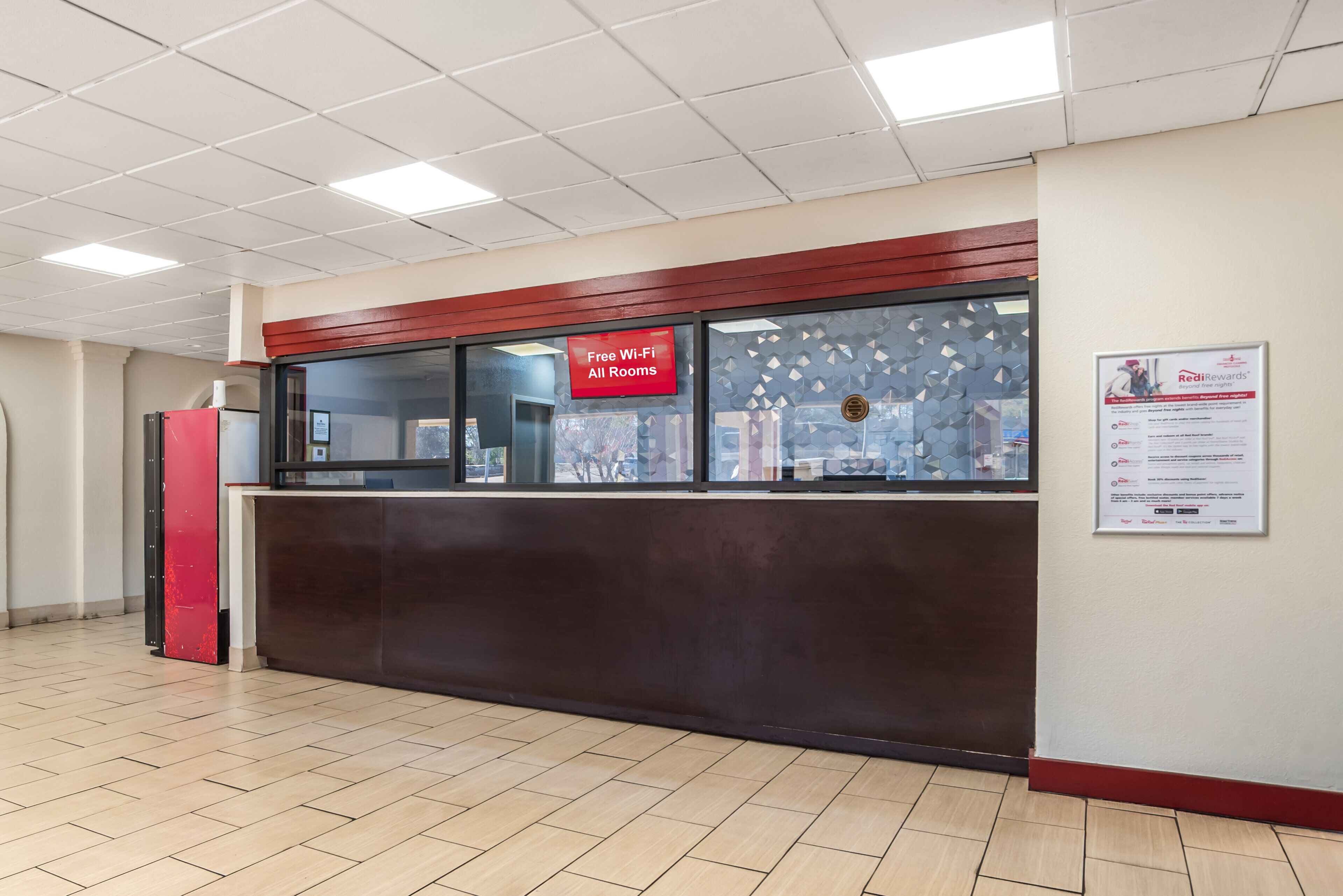 A reception desk with a sign indicating free Wi-Fi in all rooms.