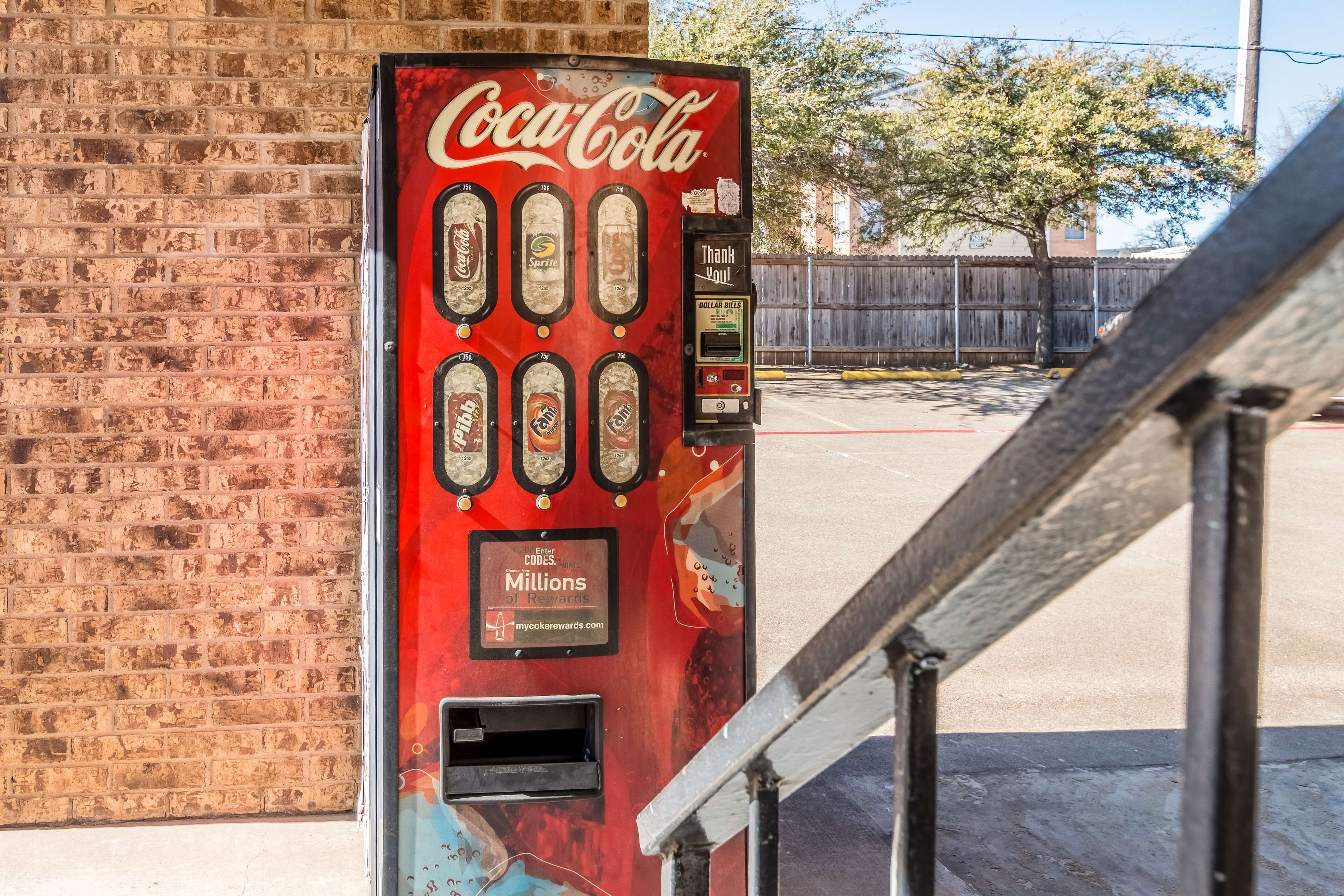 A Coca-Cola vending machine with a 'Thank You' sign and a 'Dollar Bills' slot.