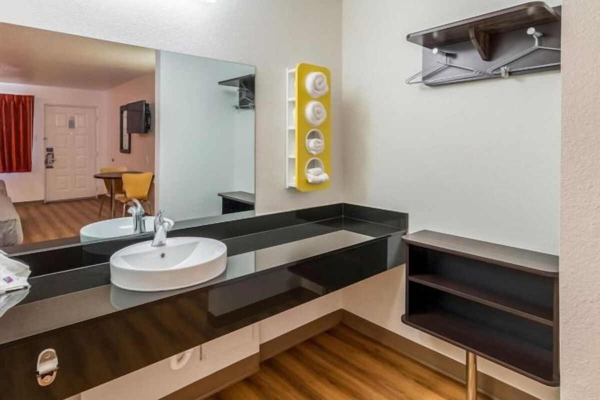 A modern bathroom with a black countertop sink, a mirror, and a towel rack.