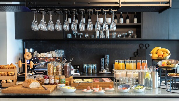 A breakfast buffet with various food items, beverages, and a selection of wine bottles. - Conscious Hotel Museum Square (Amsterdam)