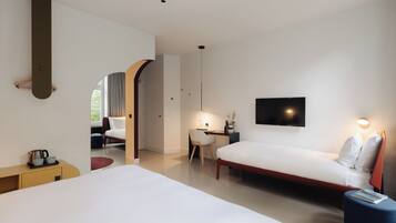Ein modernes Hotelzimmer mit einem großen Bett, einem Schreibtisch, einem Sessel, einem Fernseher und einem kleinen Tisch mit einem Buch.