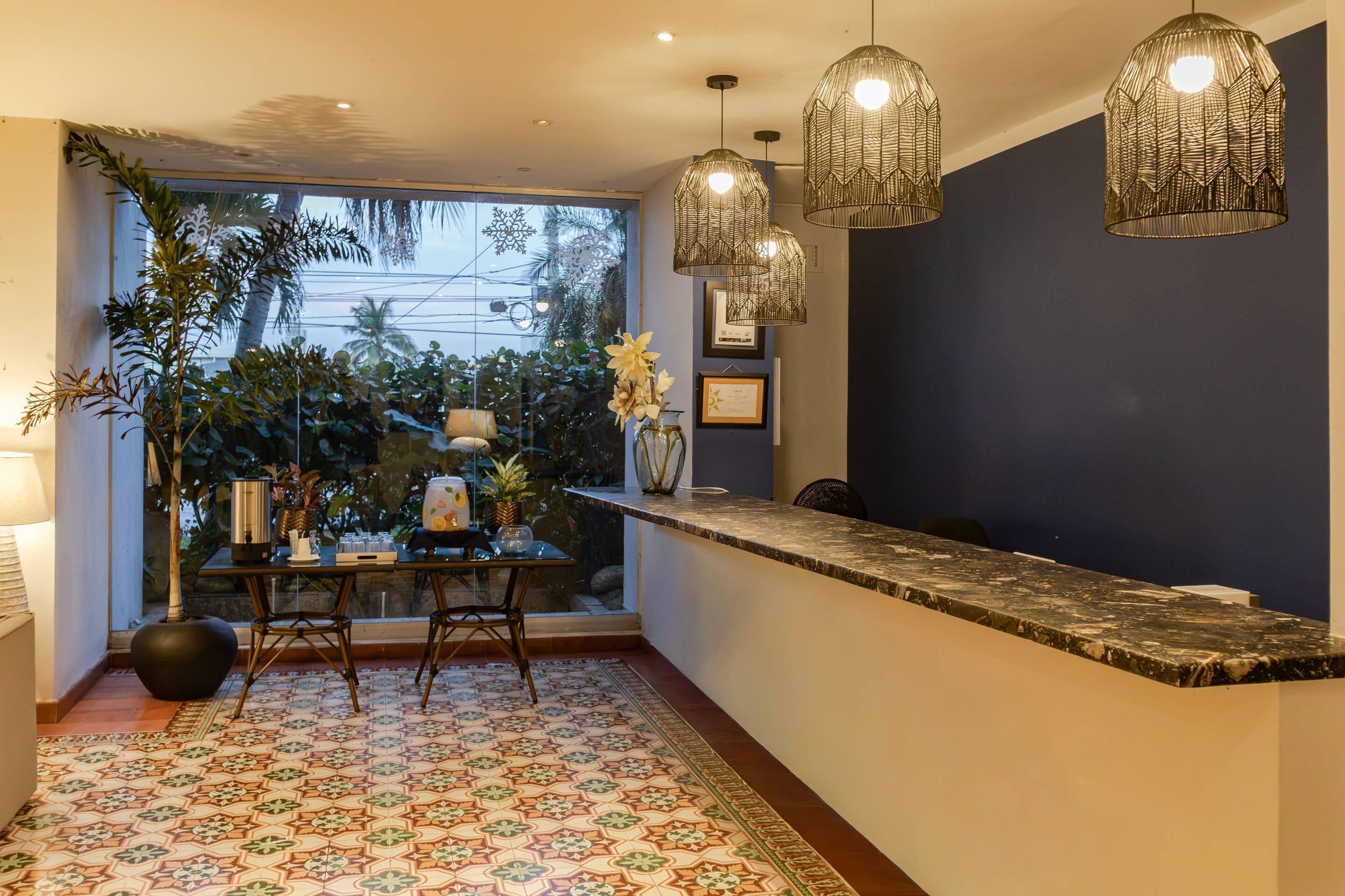 A modern kitchen with a large window, a dining table, and hanging pendant lights.