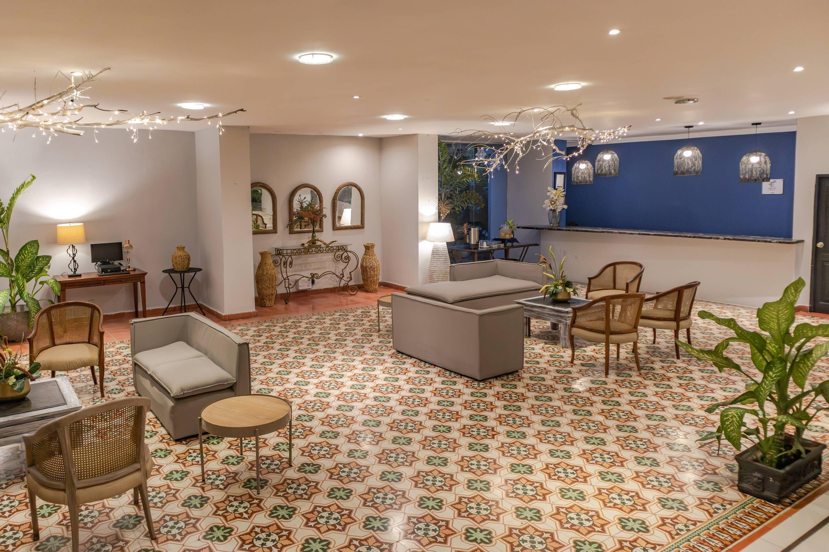 Un vestíbulo de hotel con pisos estampados, arreglos de asientos y elementos decorativos.