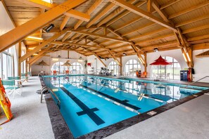 Una piscina techada, sillones reclinables de piscina