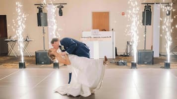 Une cérémonie de mariage où un couple s’embrasse, entouré de haut-parleurs et d’équipements d’éclairage.