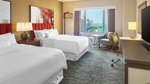 A hotel room with two beds, a desk, a chair, a TV, and a large window with a city view. - The Westin Michigan Avenue Chicago (Chicago)