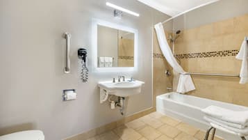 Un baño moderno con lavamanos, espejo, inodoro y bañera.