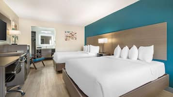 A hotel room with two beds, a desk, a chair, a TV, and a bathroom.