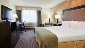 A hotel room with a large bed, a desk with a chair, a television, and two lamps. - Holiday Inn Express Union City (San Jose) by IHG (Union City)