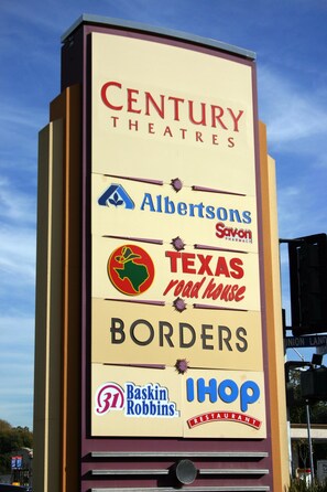 A sign with CENTURY THEATRES, Albertsons, Savon Pharmacy, Texas Road House, Borders, Baskin Robbins, and IHOP.