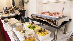A buffet with various food items including meats, salads, and desserts. - Hotel Regina (Vienna)