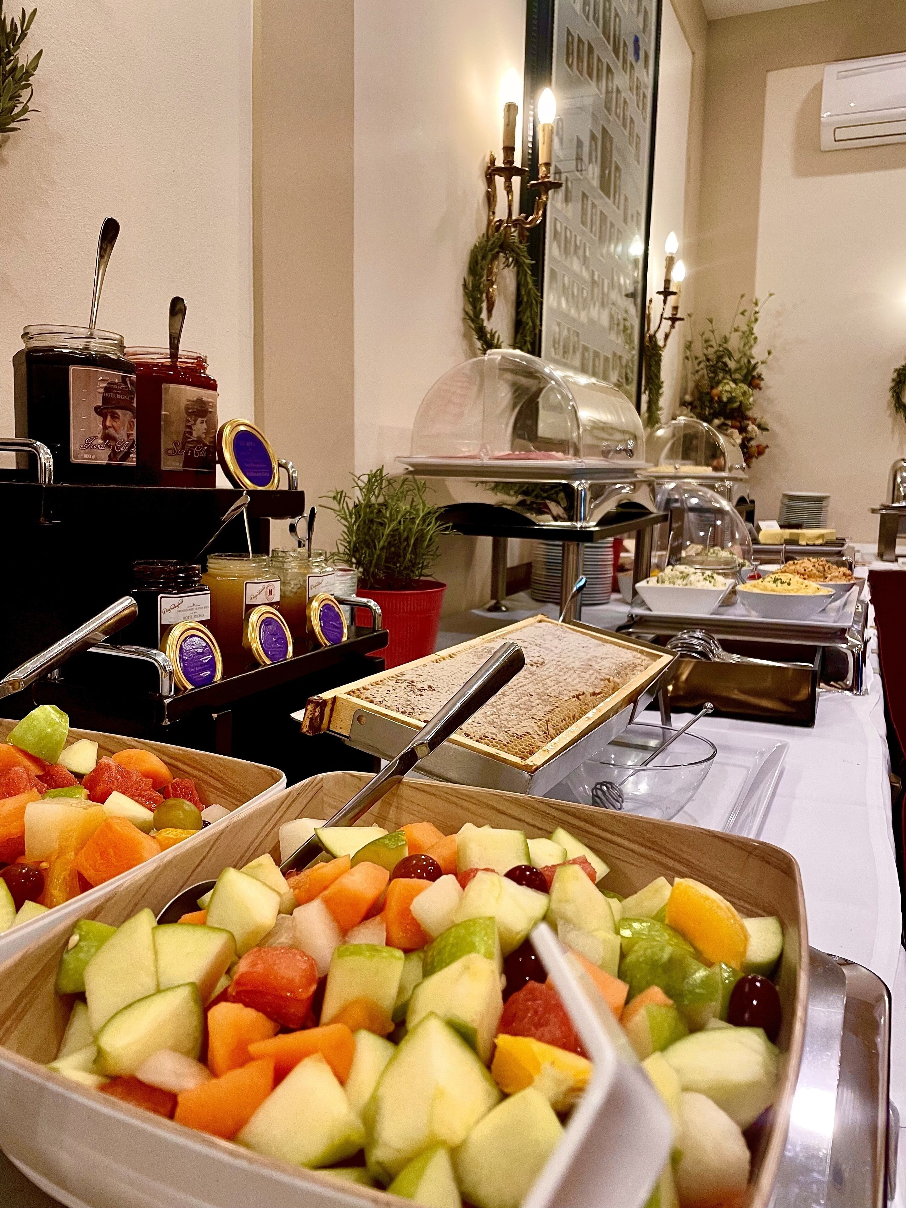 Un buffet proposant une variété de plats, notamment des fruits et des sandwichs.