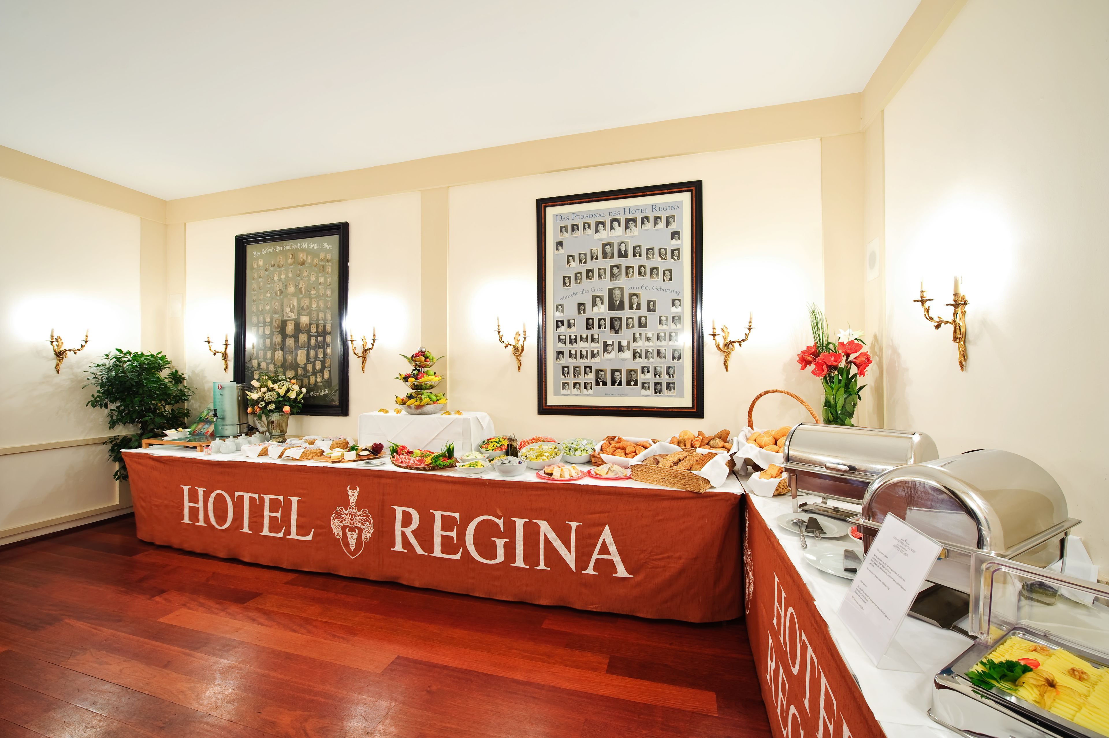 A buffet table at Hotel Regina with various food items and a framed photo on the wall.