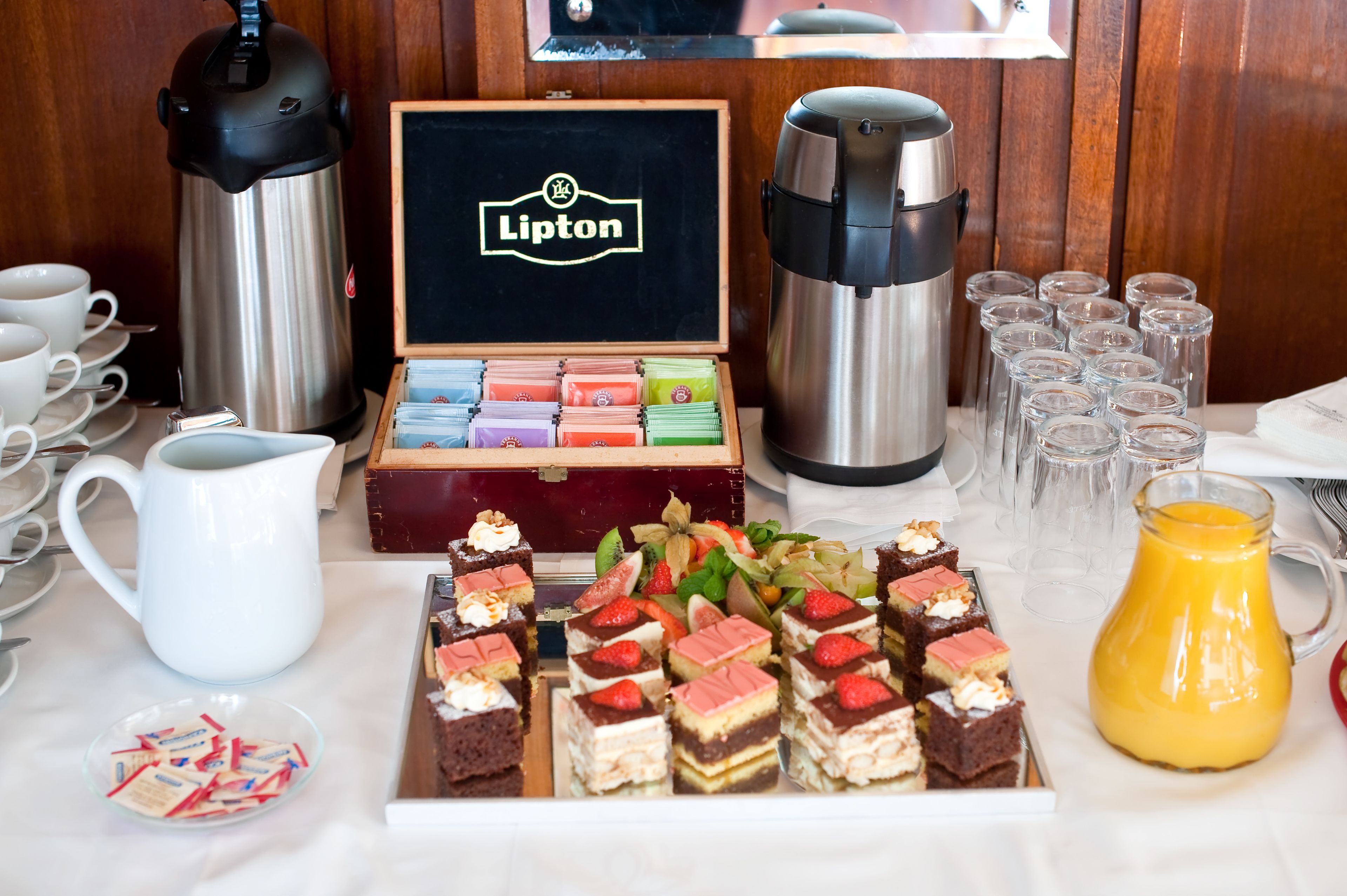 Ein Buffet mit verschiedenen Speisen, einer Kaffeestation und einer Lipton Teeauswahl.