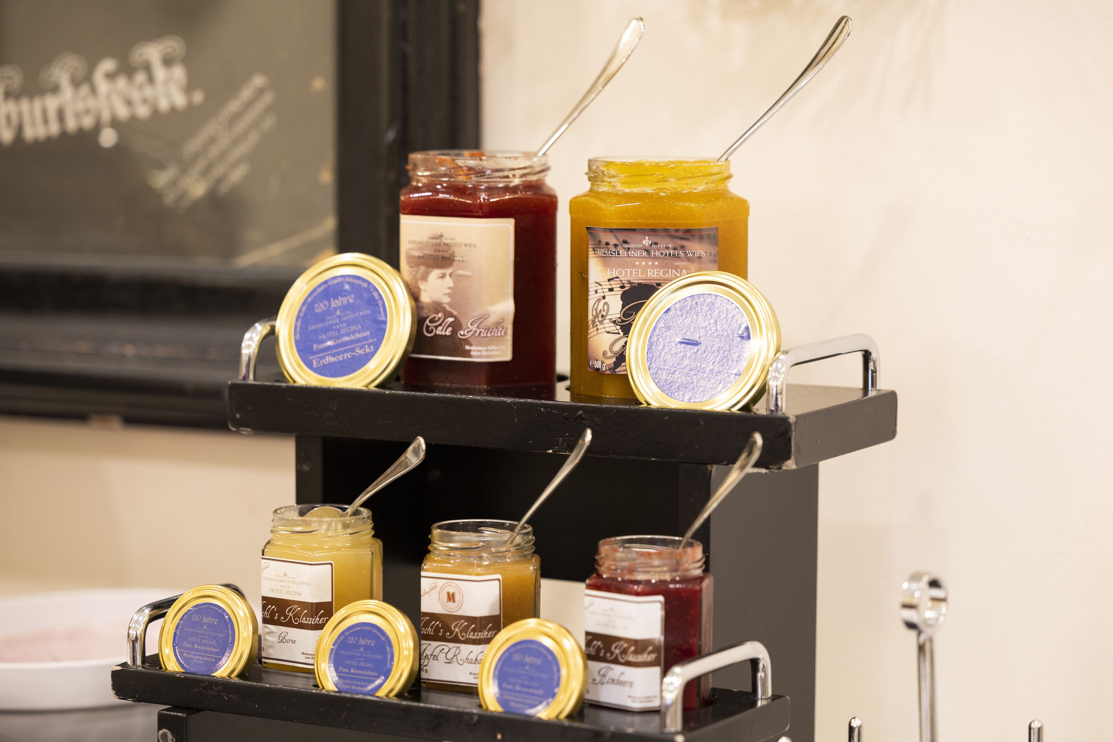 A display of various jars of honey and jam on a shelf.