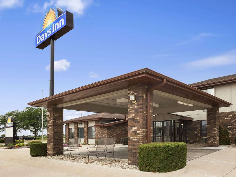 Um Days Inn com entrada coberta, fachada de tijolos e área de estacionamento.