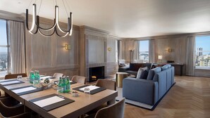 A modern hotel room with a dining area, a fireplace, a sofa set, and large windows offering city views. - The Clift Royal Sonesta San Francisco (San Francisco)