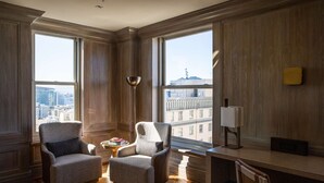 A spacious room with large windows, two armchairs, a small table with books, and a lamp. - The Clift Royal Sonesta San Francisco (San Francisco)