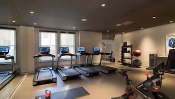 A gym with treadmills, an elliptical, a stationary bike, and a weight rack.