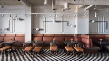 A restaurant interior with booth seating, tables, and chairs.