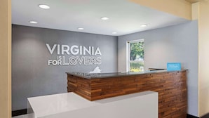 Una recepción con diseño de paneles de madera, un cartel que dice “VIRGINIA IS FOR LOVERS” y un letrero de Hilton Honors.