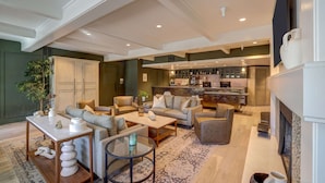 A spacious living room with a fireplace, a kitchen in the background, and a bar area. - Sonoma Valley Inn, Tapestry Collection by Hilton (Sonoma)