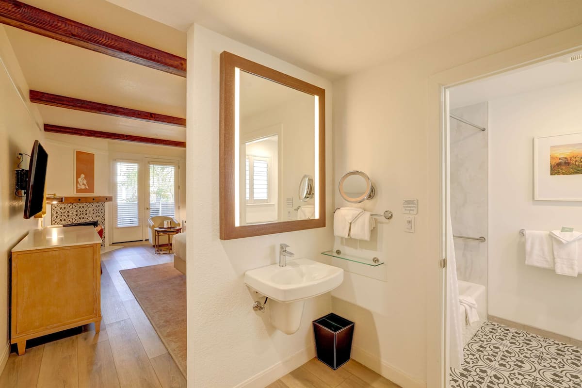 Un baño con lavabo, espejo y ducha.