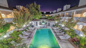 A rooftop pool with lounge chairs and a gazebo, surrounded by greenery and modern buildings. - Sonoma Valley Inn, Tapestry Collection by Hilton (Sonoma)