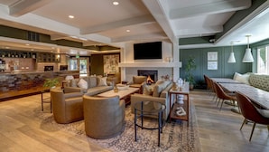 A spacious living area with a fireplace, comfortable seating, a bar, and a dining area. - Sonoma Valley Inn, Tapestry Collection by Hilton (Sonoma)