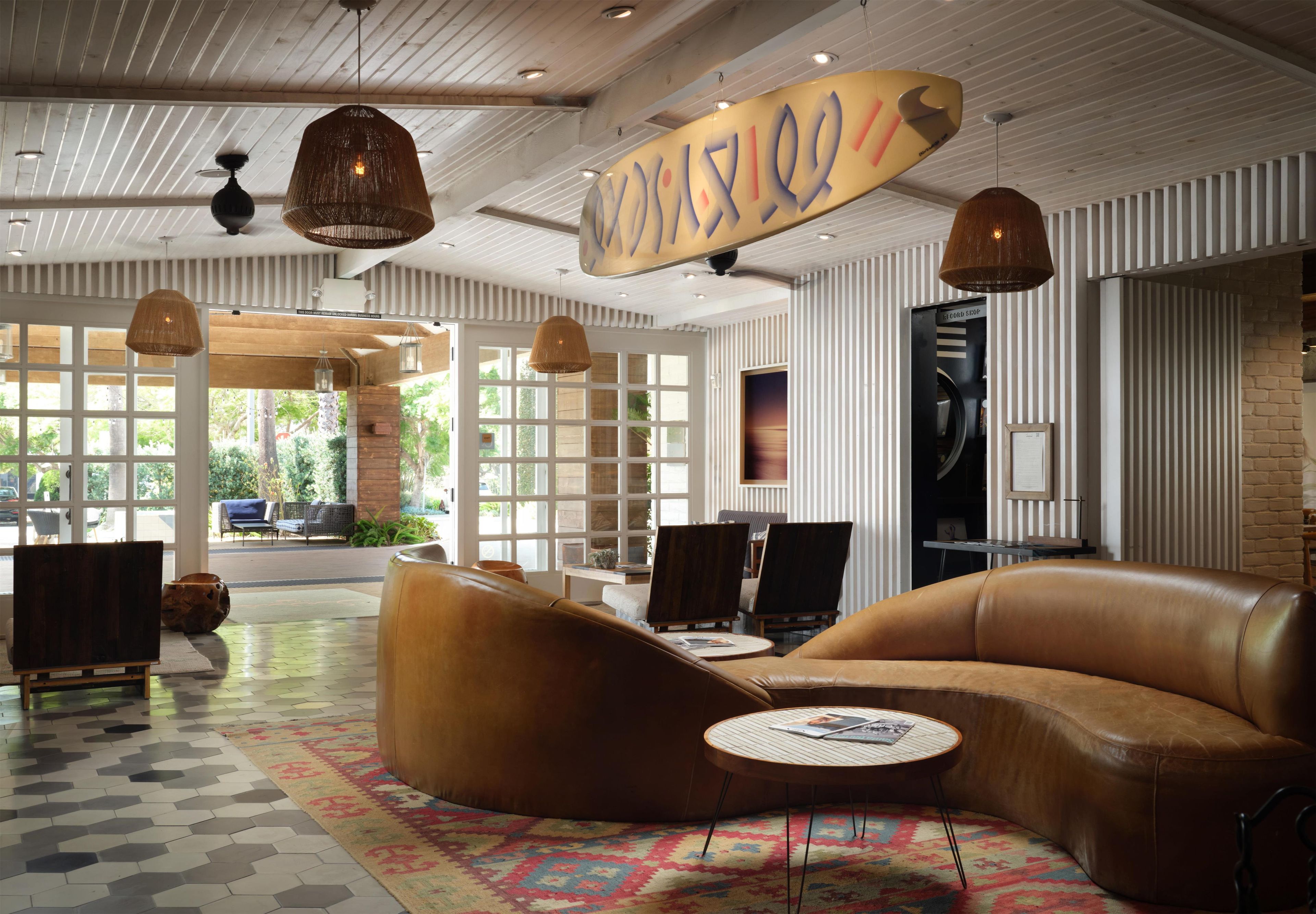 A spacious lobby with leather seating, a patterned rug, and a large window offering a view of the outdoors.