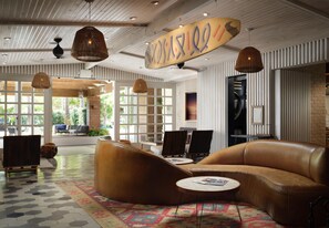 A spacious lobby with leather seating, a patterned rug, and a large window offering a view of the outdoors.