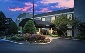 A hotel entrance with a covered driveway and a sign indicating a clearance of 9'8'. - The Burgundy Hotel, Tapestry Collection by Hilton (Little Rock)