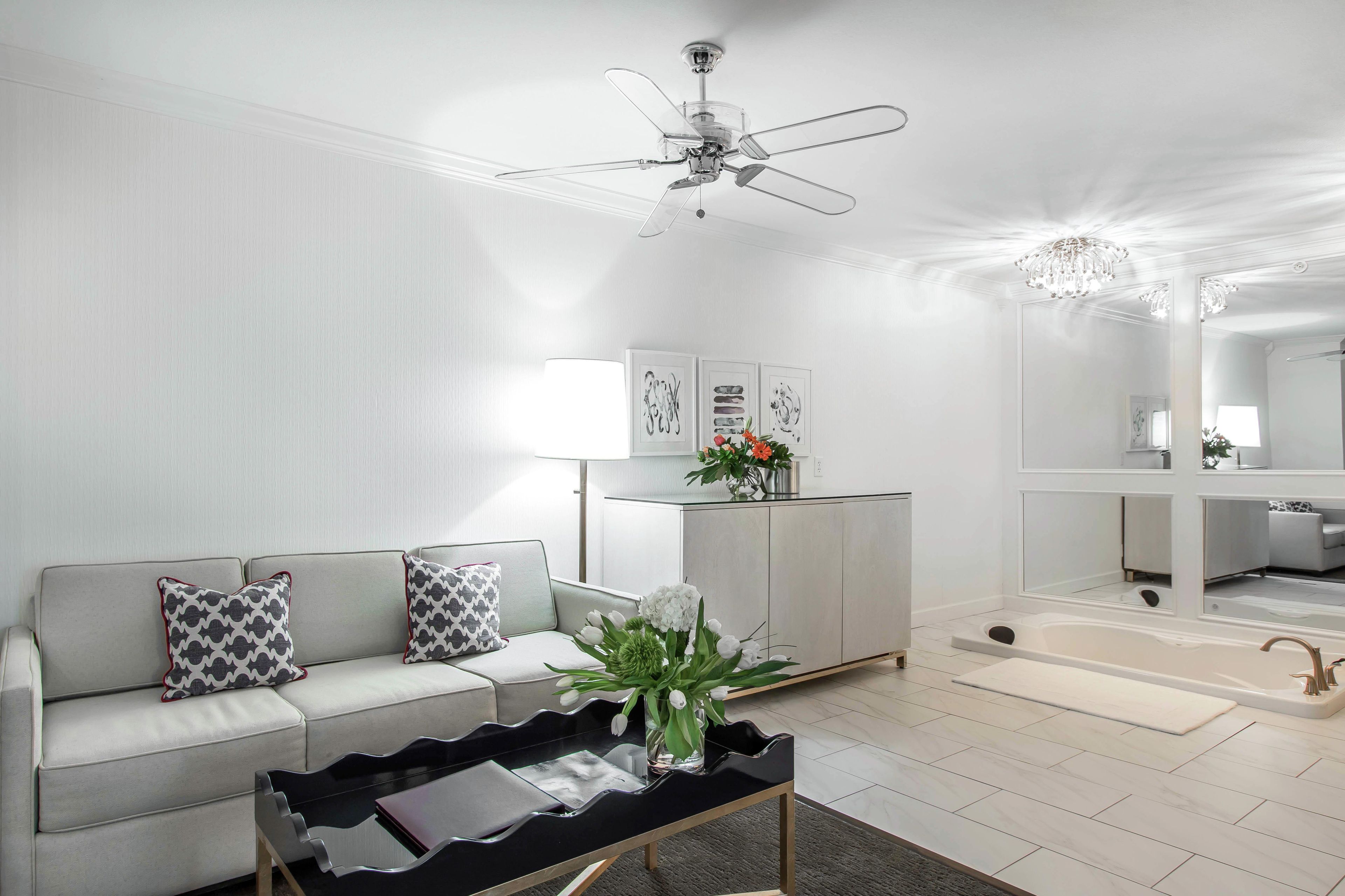Un salon moderne avec un canapé, une table basse et un ventilateur de plafond.