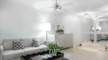 A modern living room with a sofa, coffee table, and a ceiling fan.