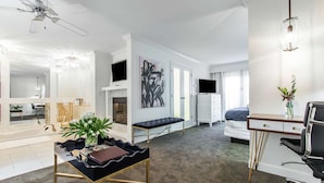 A modern hotel room with a dining area, a living space, and a bedroom. - The Burgundy Hotel, Tapestry Collection by Hilton (Little Rock)