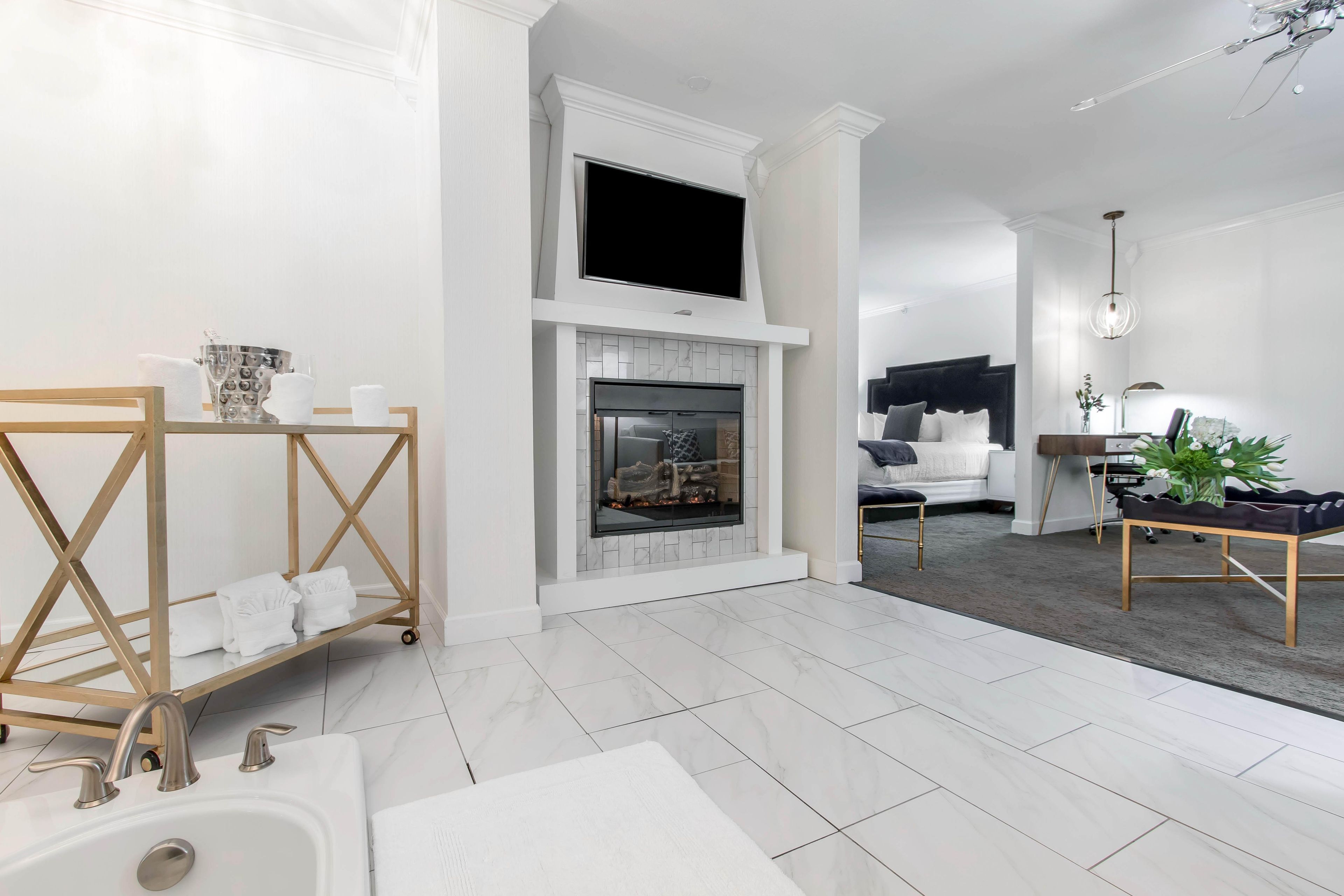 Ein modernes Wohnzimmer mit Kamin, einer Couch, einem Couchtisch und einem Fernseher, der über dem Kamin angebracht ist.